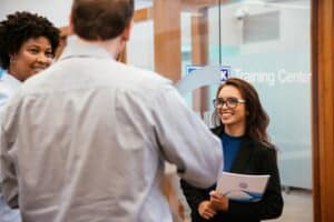 Three atwork coworkers talking with one another in the lobby