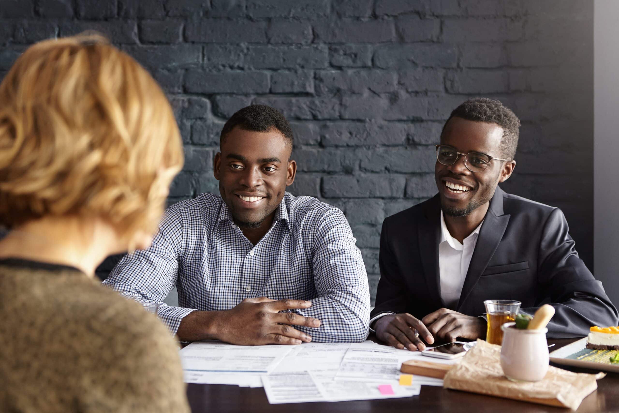 Happy African-American CEO and HR director smiling cheerfully during job interview