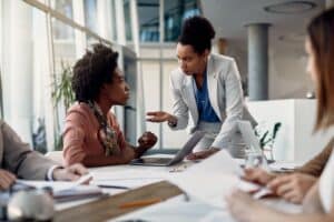 Female CEO discusses with business apprentice on meeting at corporate office.