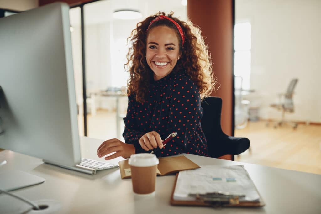 smiling business professional sitting at her desk